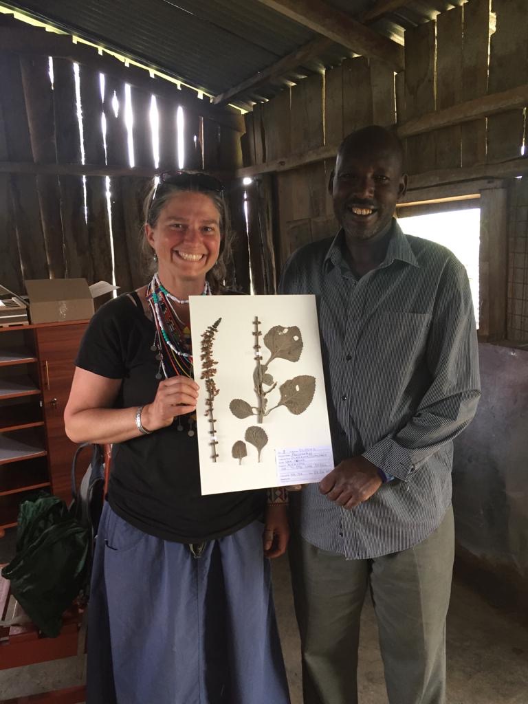 A woman and man hold a speciman sheet.