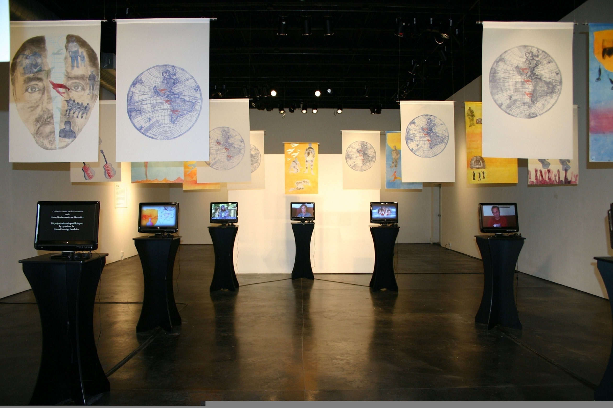 Photograph of a room with monitors and banners hanging from the ceiling.